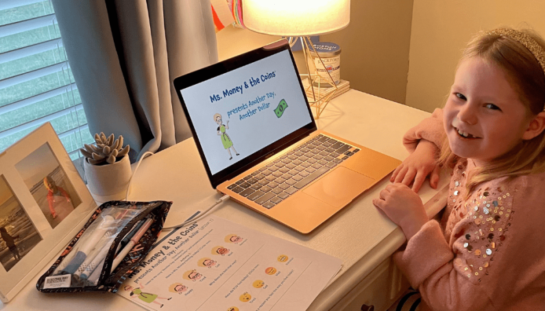 little girl learning about money at computer