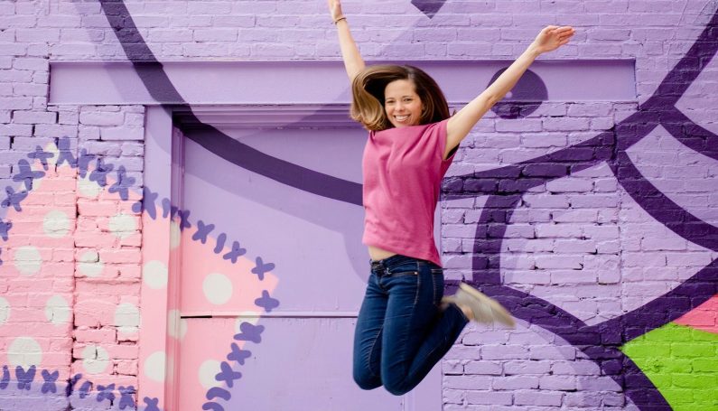 woman jumping in the air, feeling free and happy because of her social media break