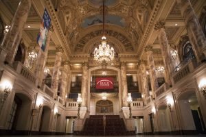 Boch Center Theater Lobby. Painted ceiling, large chandelier, and red carpeted stairs