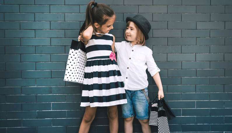 two children holding shopping bags (kids resale and consignment shops in Boston)