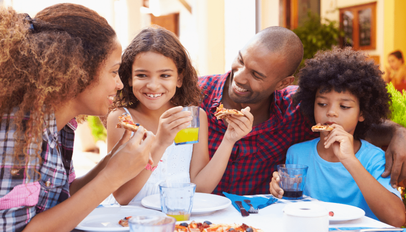 family eating pizza outdoors (best outdoor dining Boston families)