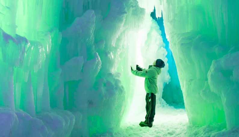child in ice tunnel in the ice castles in Woodstock, NH (go where there's snow in New England)