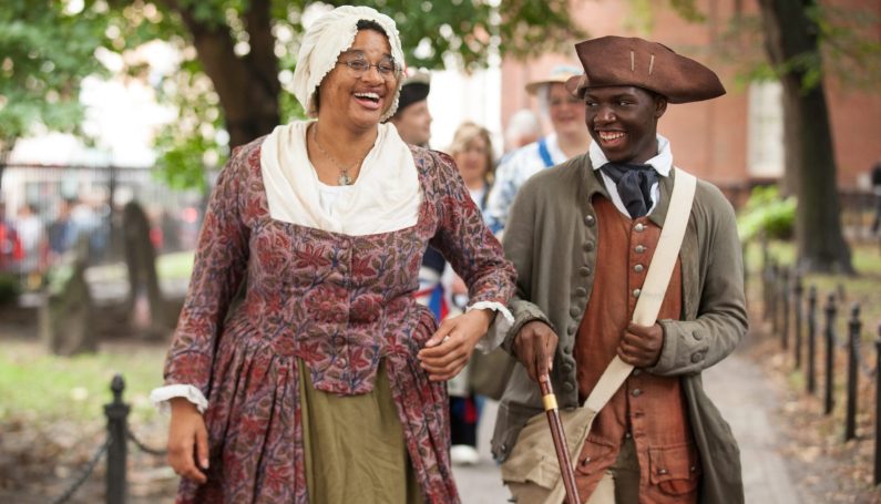 African American 18th century costumed guides walking and laughing (Black History Month in Boston)
