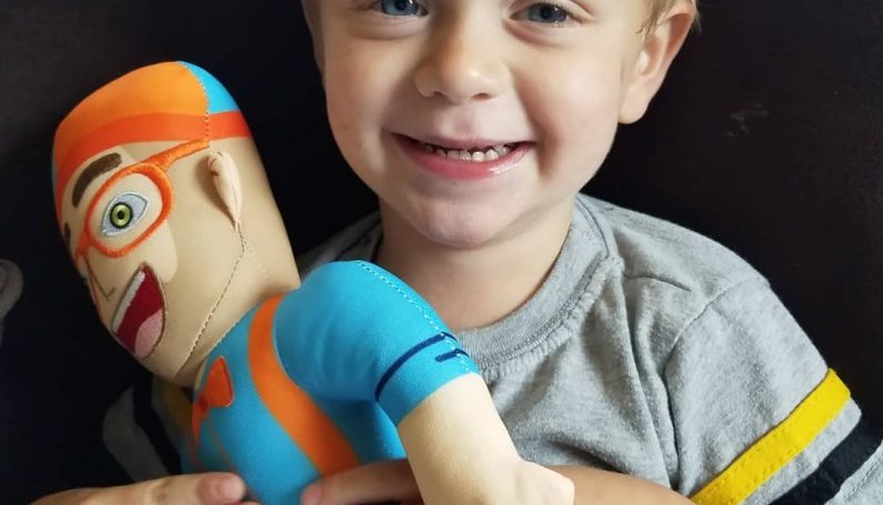 young child holding a Blippi doll