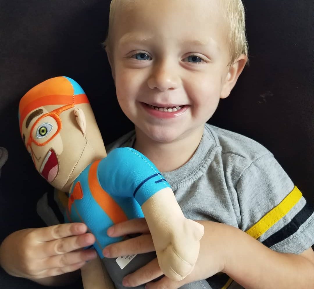 young child holding a Blippi doll
