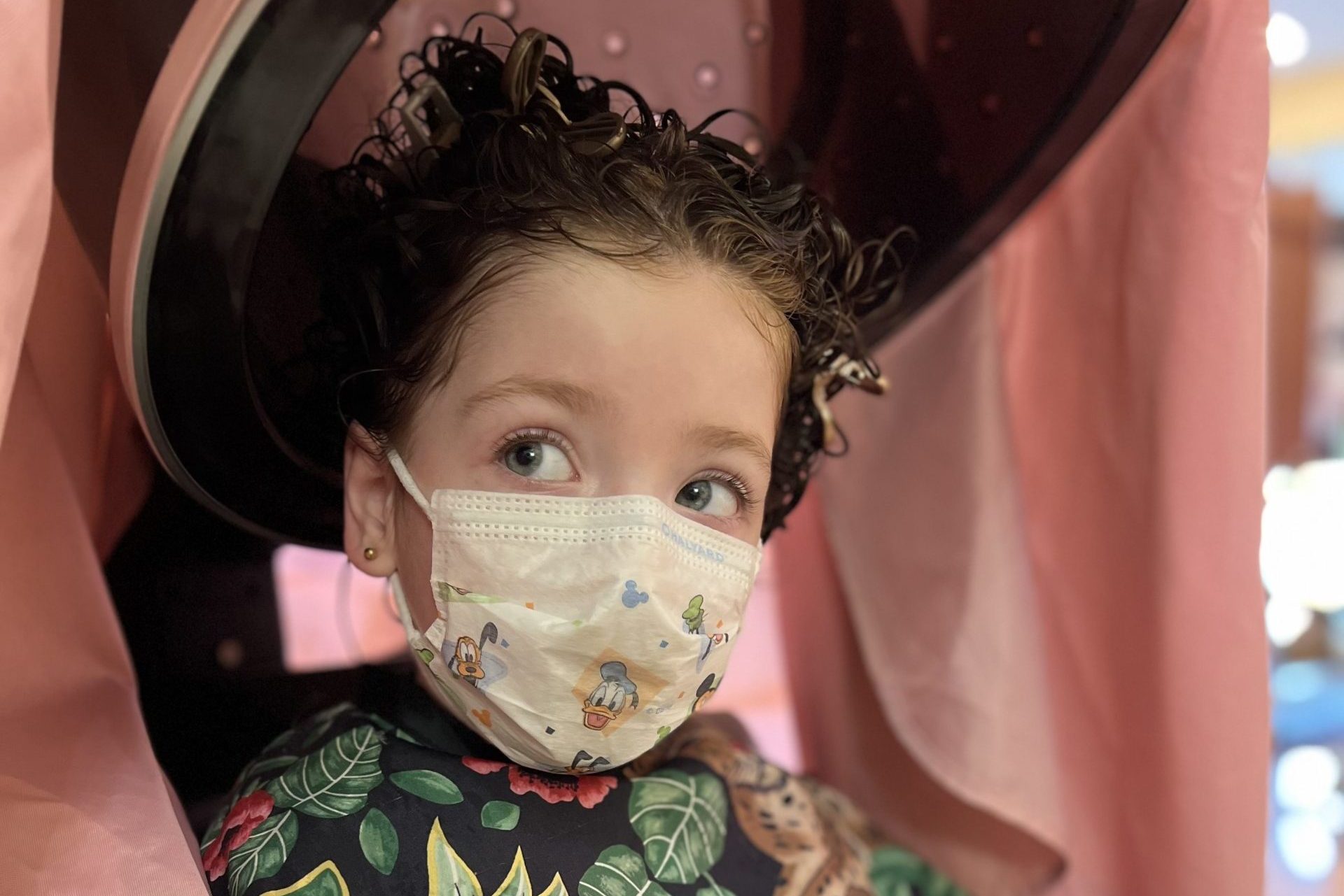 girl with curly hair and a mask