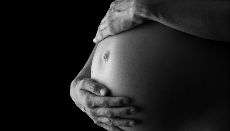 woman holding pregnant belly (IVF, pregnancy, miscarriage)