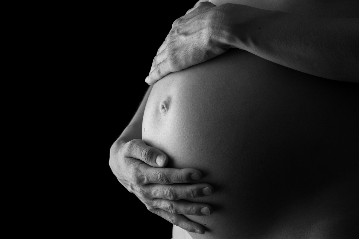 woman holding pregnant belly (IVF, pregnancy, miscarriage)