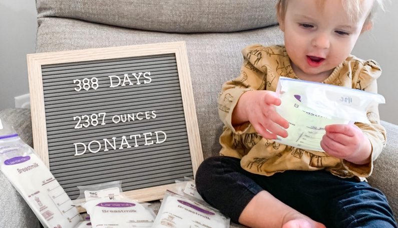 baby with sign celebrating breastmilk donation