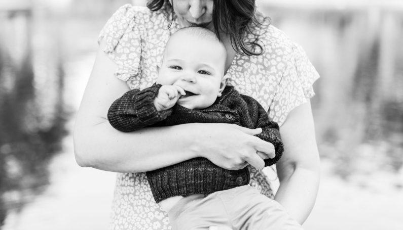 Mother holding baby and kissing the top of his head