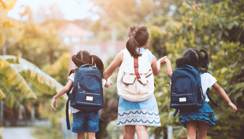three young girls wearing backpacks