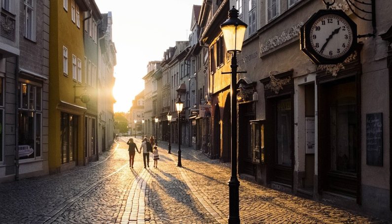 family walking on a cobblestone city street at sunset (Europe with kids)