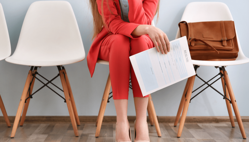 woman sitting on chair holding resume