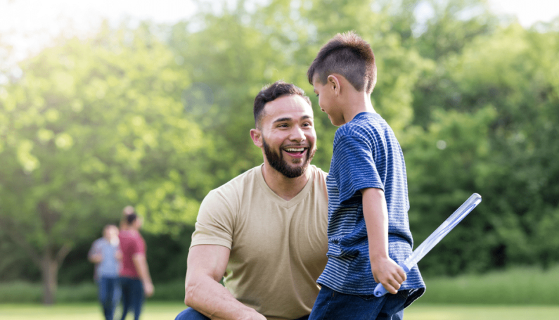 dad and son smiling together outdoors
