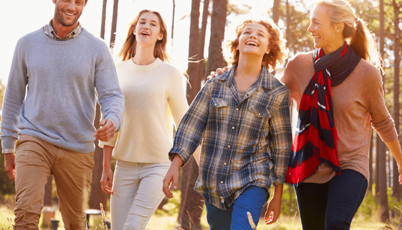 two parents and two teenagers on a walk outdoors (how to have a fun family weekend)