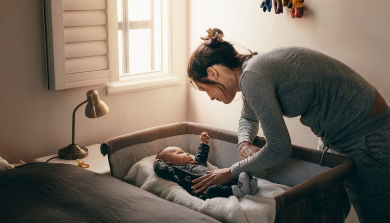 mother putting baby to bed in crib (to the mother whose child doesn't sleep)