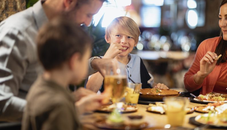 A family having a meal together in a restaurant. (family-friendly Irish pubs in Boston for St. Patrick's Day)