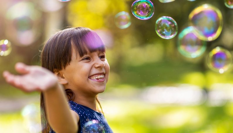 girl playing with bubbles outside (good kid, bad kid)