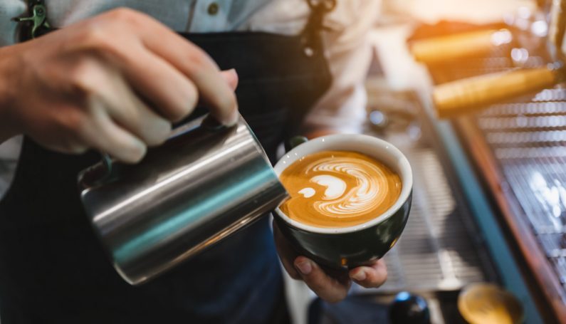 barista making latte art in cup of milk and coffee (coffee shops Boston North Shore)