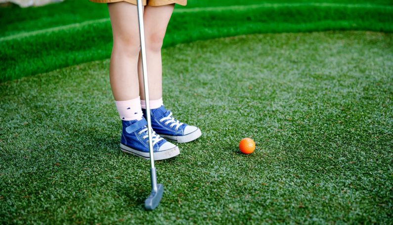 preschool girl playing mini golf with family (Boston mini-golf courses)