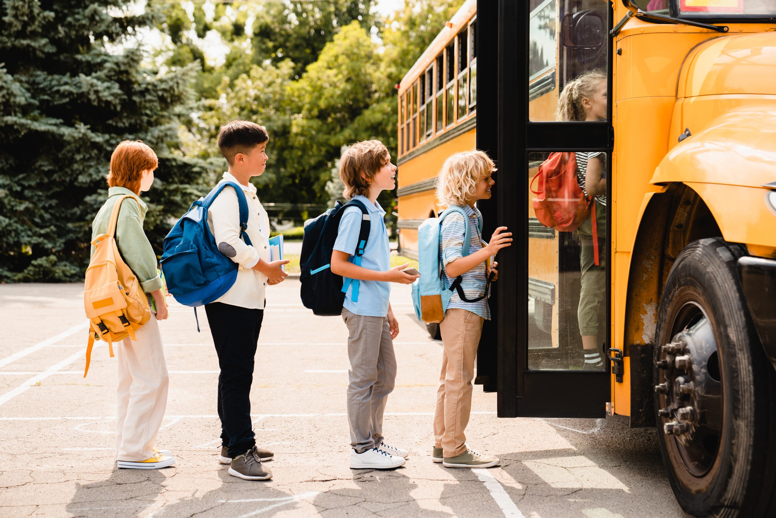 children lined up outside yellow school bus (school bus driver)