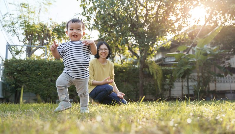 smiling Asian child and his young mother in nature with sunlight (toddler parenting hacks)