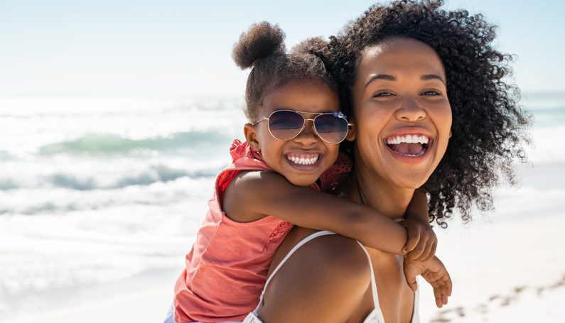 smiling mother and daughter at the beach (18 summers mom)