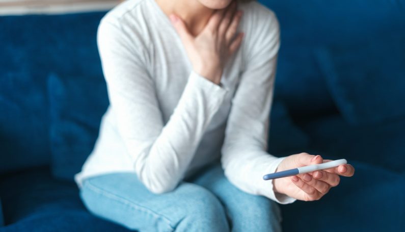 woman with pregnancy test (pregnancy loss, pregnancy after miscarriage)