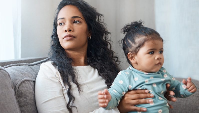 woman with serious expression holding baby on her lap (mothers mental health SSRIs)