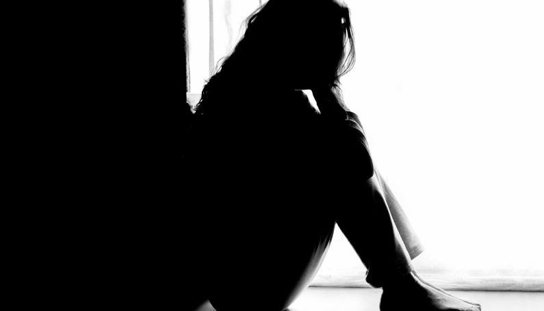 Unhappy woman sitting on floor (miscarriage advice)