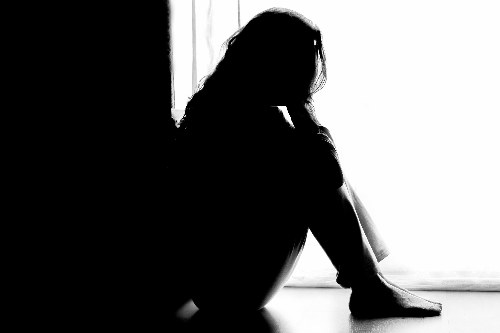 Unhappy woman sitting on floor (miscarriage advice)