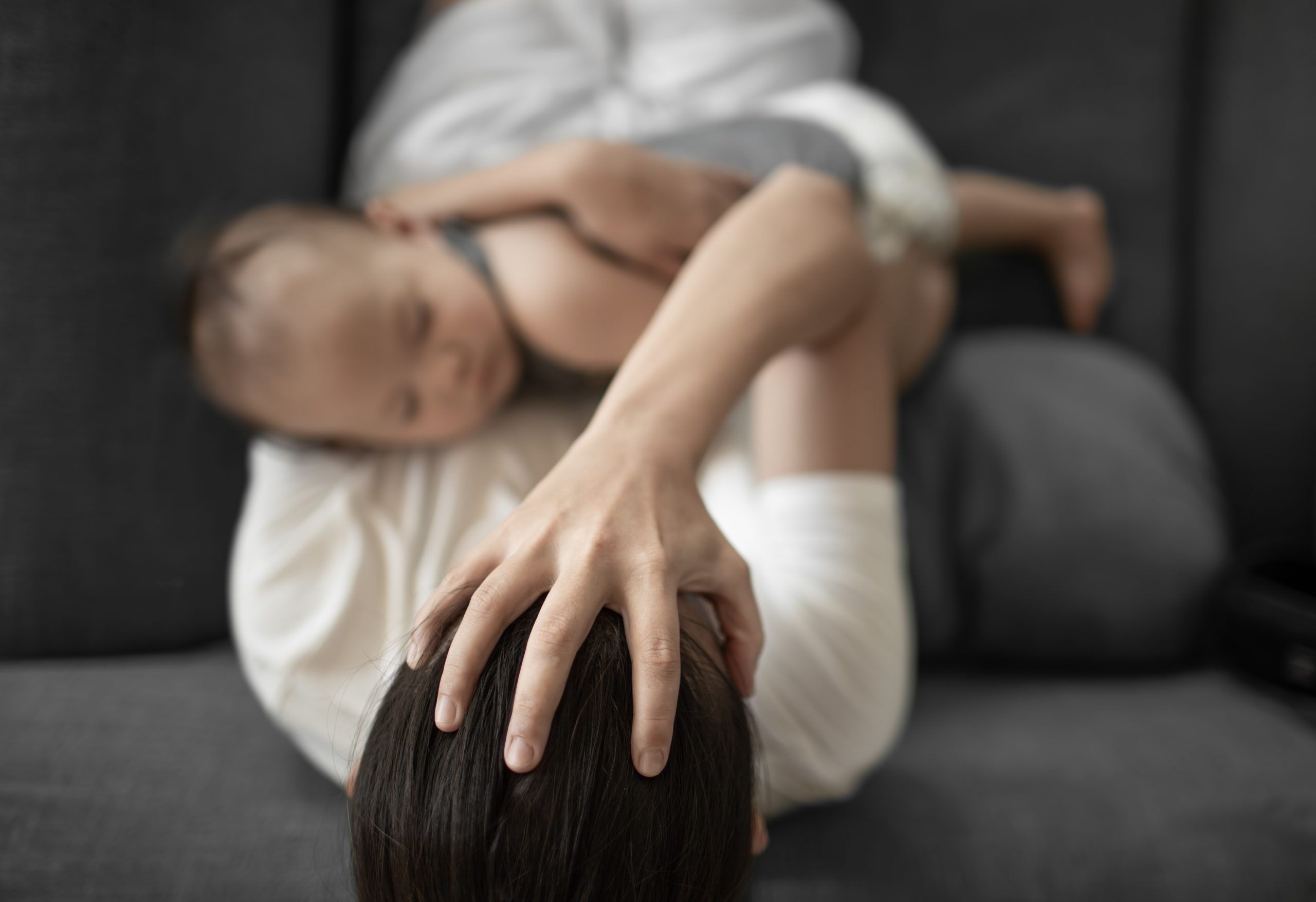 mother with baby in arms, headache, multi-tasking (tired mom)