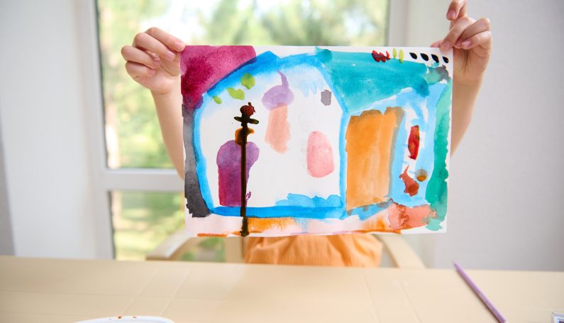 child showing watercolor painting (what to do with child's artwork)