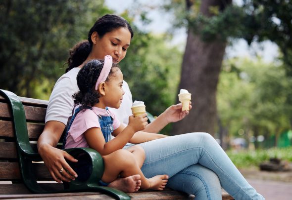 mother and daughter on park bench holding ice cream cones (how to teach accountability and honesty to kids)