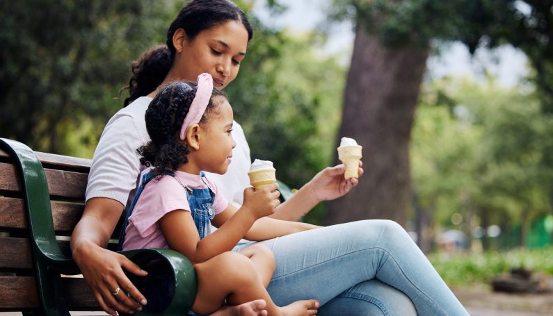 mother and daughter on park bench holding ice cream cones (how to teach accountability and honesty to kids)