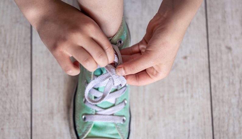child learning to tie shoes (8 things to teach your kid before they turn 8