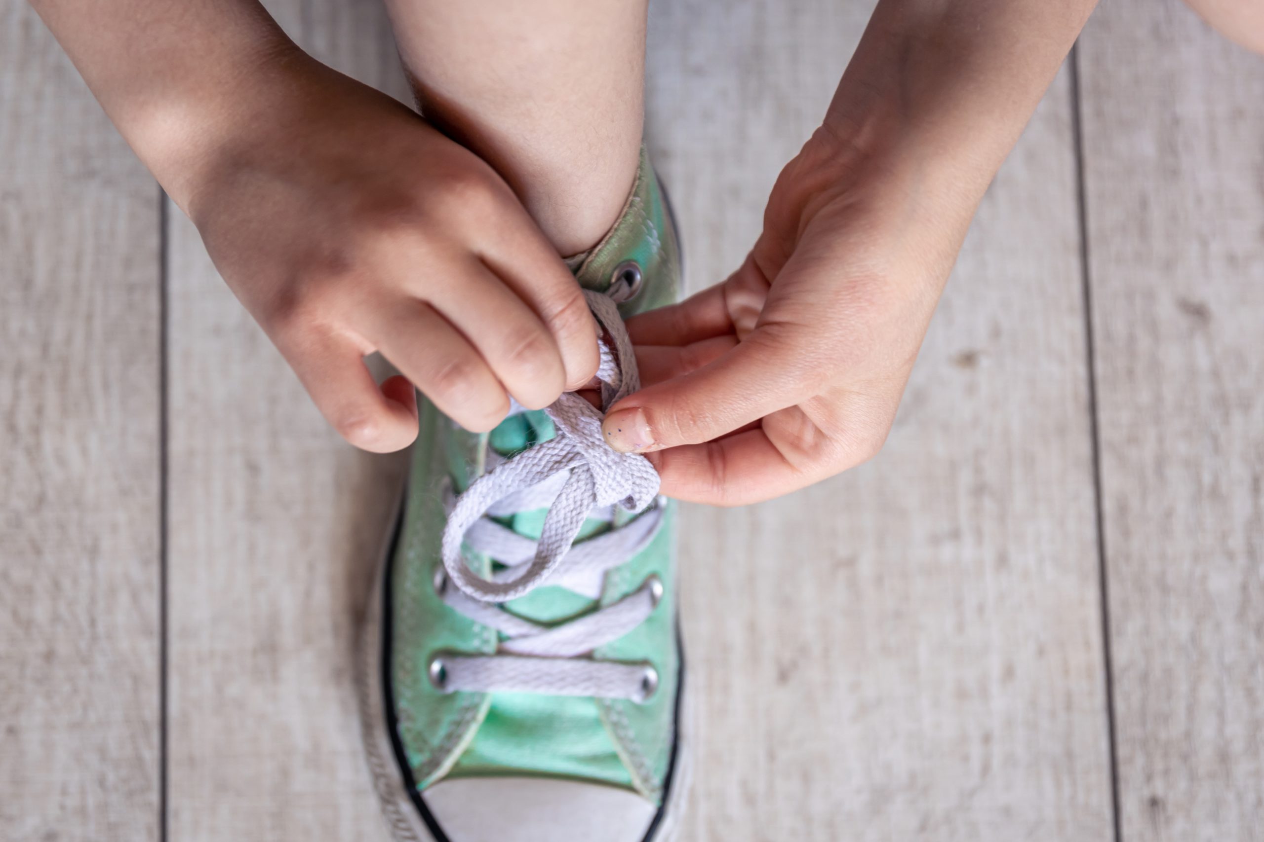 child learning to tie shoes (8 things to teach your kid before they turn 8