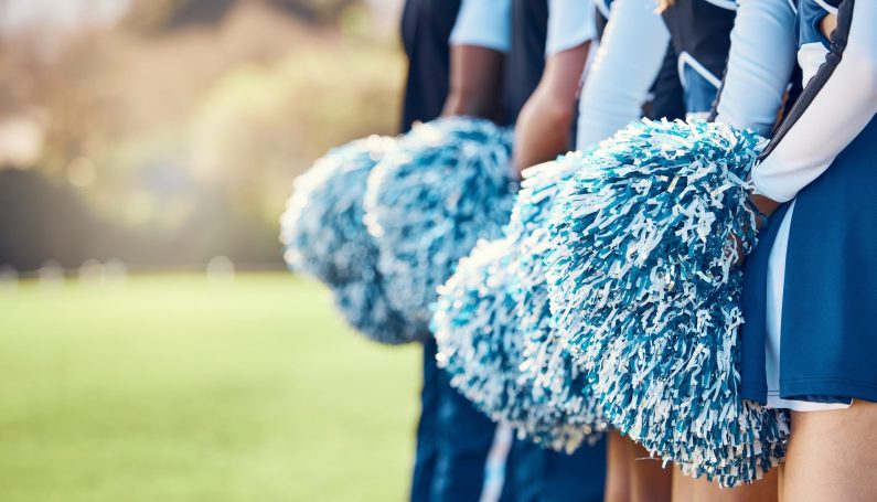 row of cheerleaders holding pom-poms (cheerleaders are athletes)