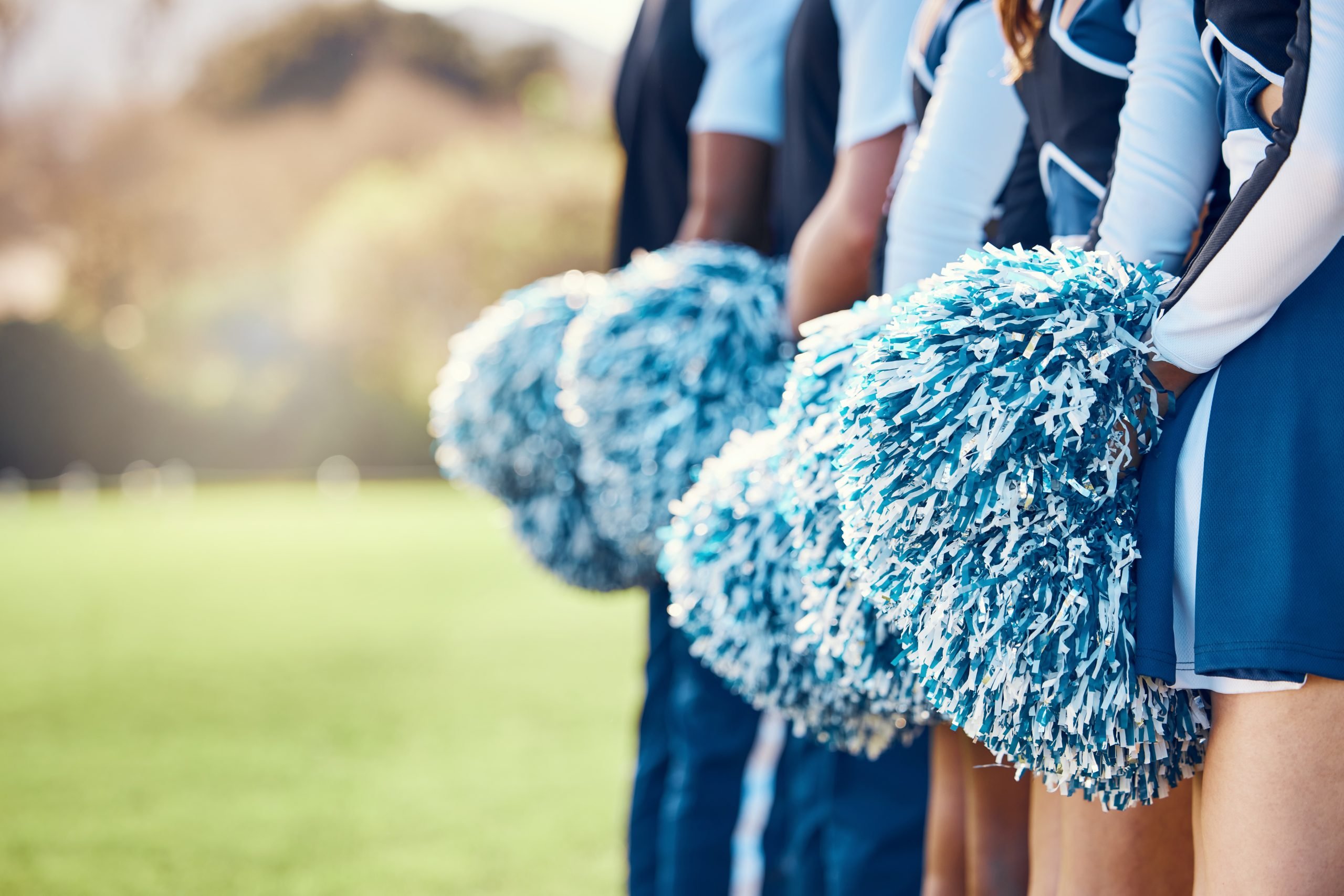 row of cheerleaders holding pom-poms (cheerleaders are athletes)