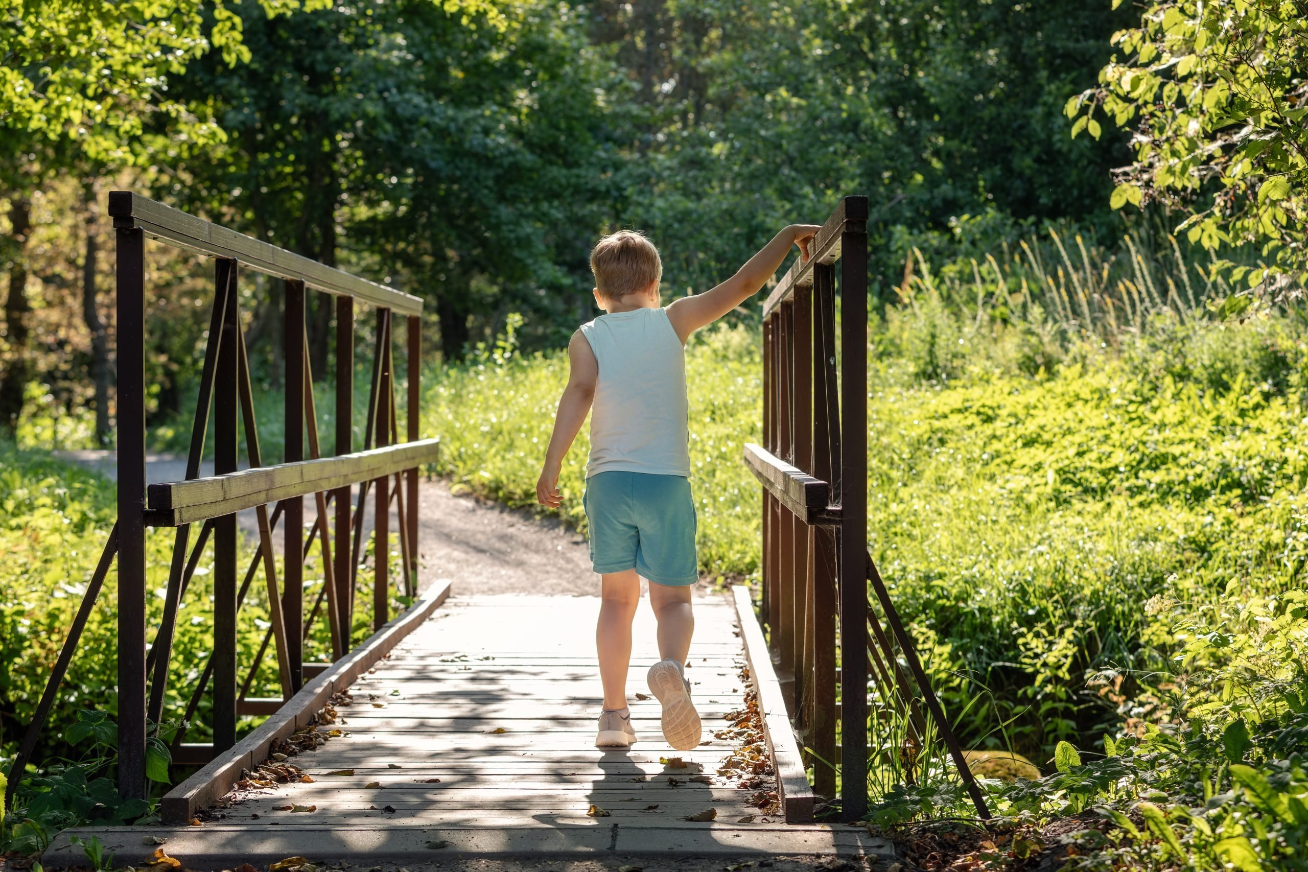 young boy walking across a bridge (free range parenting)