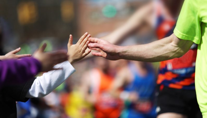 Boston Marathon runners high fiveing child spectators