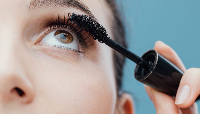 woman applying mascara (makeup for busy moms)