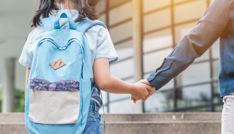 child and parent holding hands, walking to school, lessons for back-to-school season