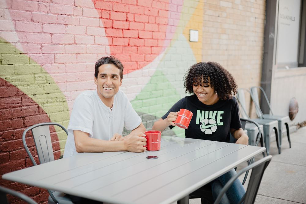 Two people sitting at a table, outside