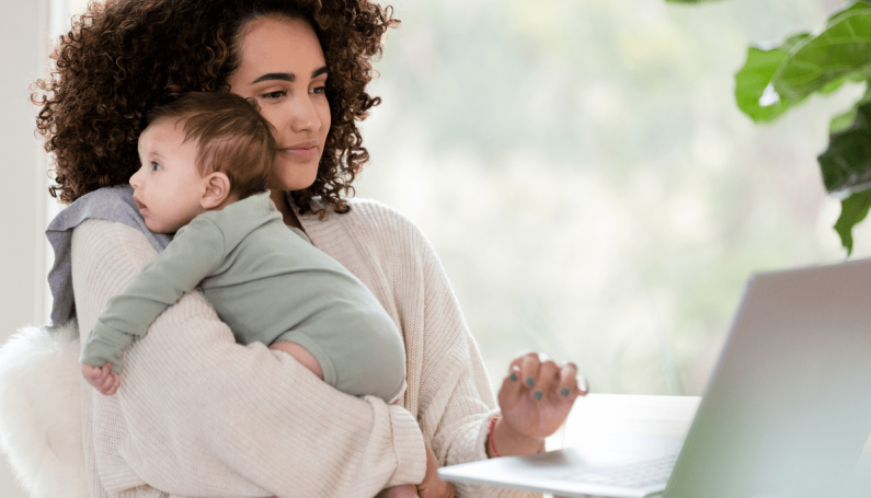 woman holding baby and typing on a computer (mom using AI and ChatGPT for parenting)