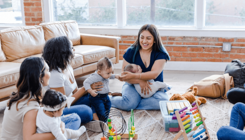 group of moms with babies sitting in a circle - mom village