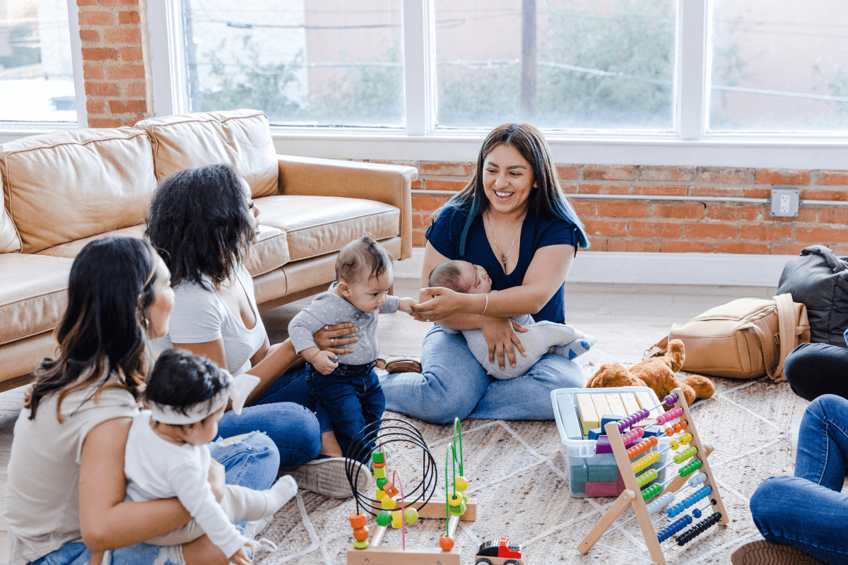 group of moms with babies sitting in a circle - mom village