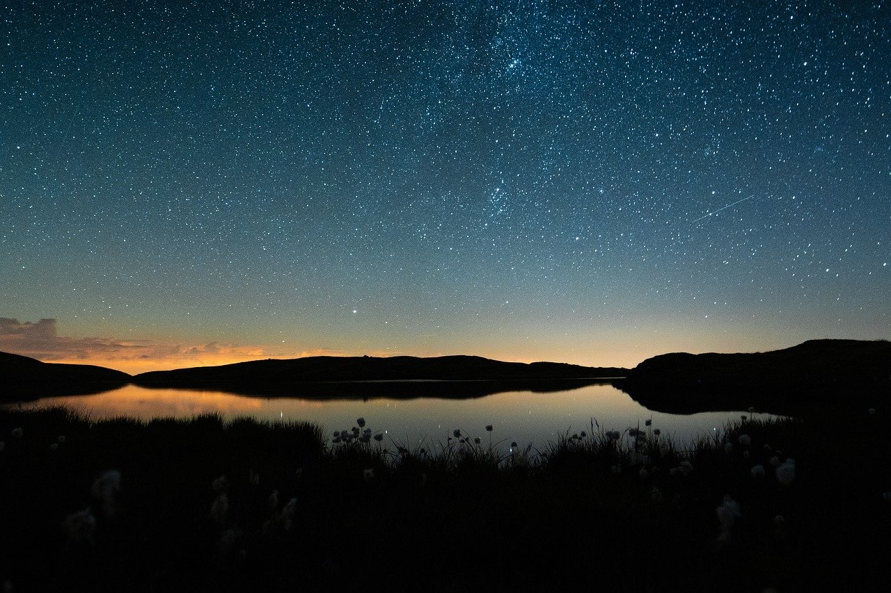 the night sky and some hills in the background
