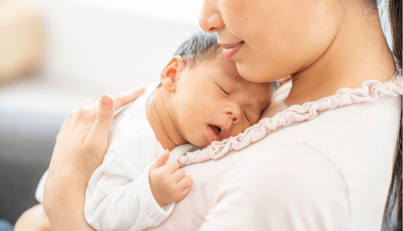 young Asian mom holding newborn baby (must haves for new moms)