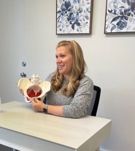 woman holding a pelvis model